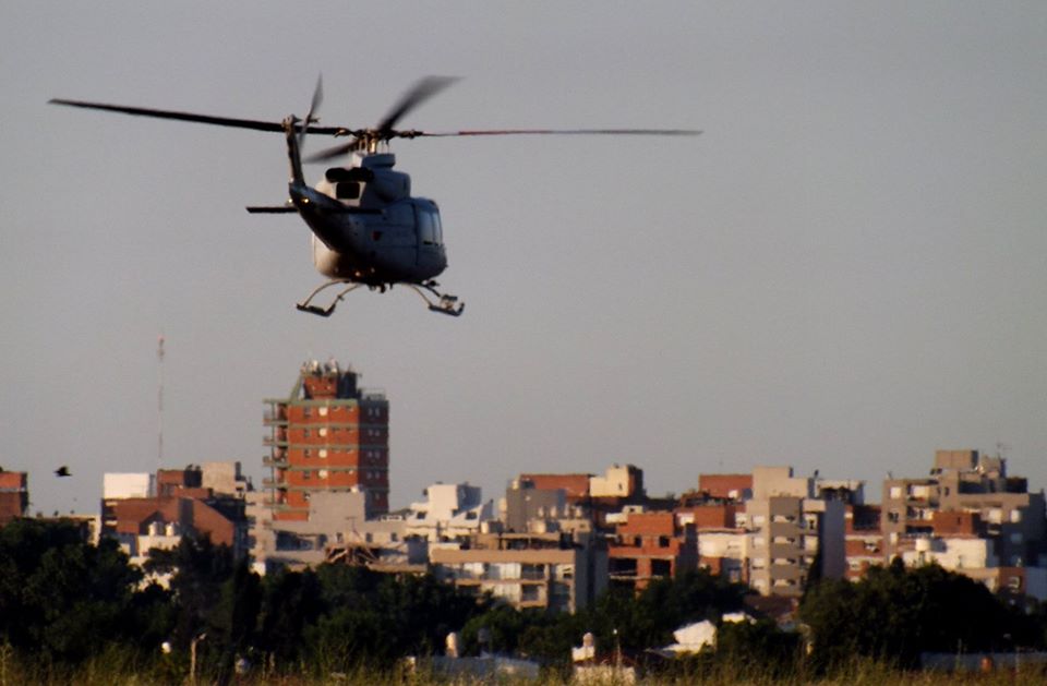 Helicóptero Bell 412 de la Fuerza Aérea Argentina despegando desde Morón. Al fondo se ven los techos y edificios de Castelar. 