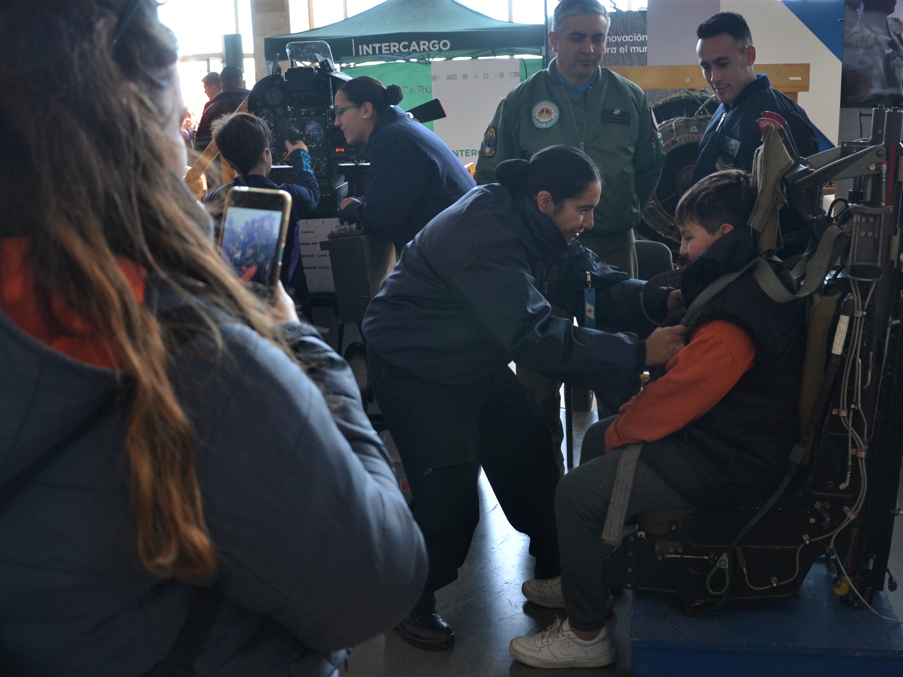 Stands de las distintas instituciones de la Fuerza Aérea. Un pequeño visitante aprende cómo funciona un asiento eyector. 