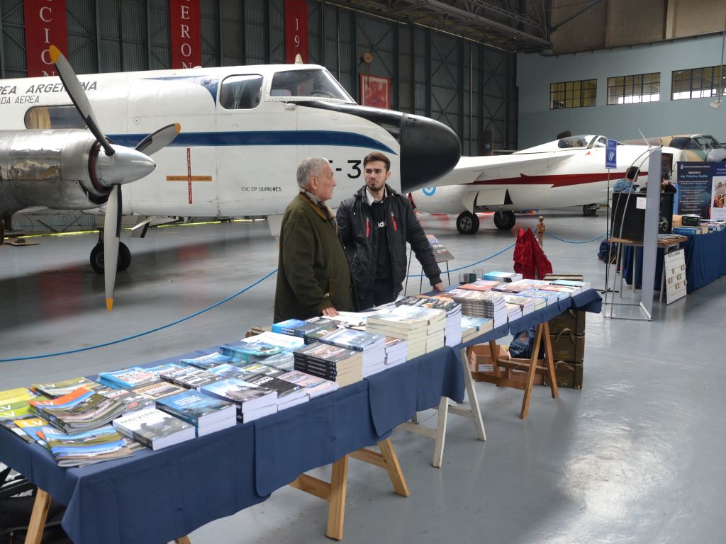 Libros entre aviones históricos. Detrás del stand un IA-50 Guaraní II y un IA-33 Pulqui II, ambos de fabricación nacional. 
