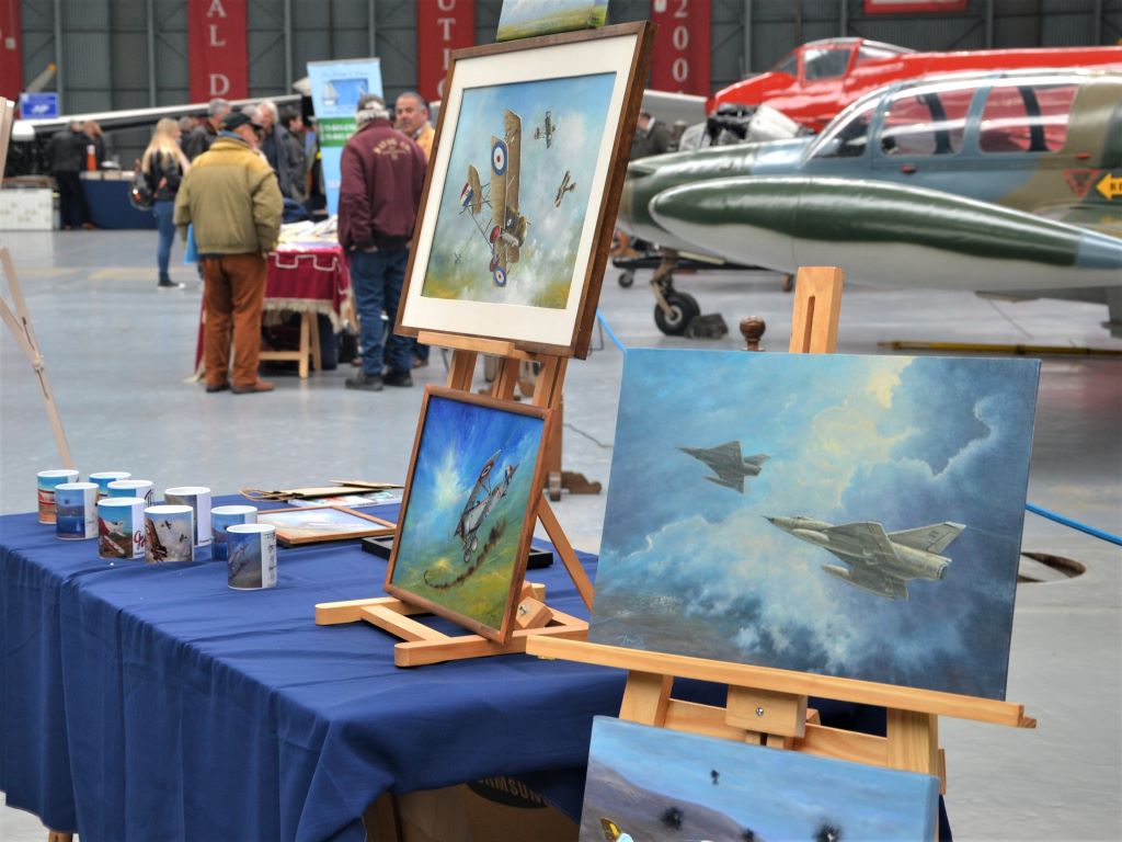 Cuadros, pinturas y libros entre aviones históricos. Archivo: 2023. 